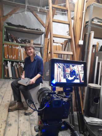 Agnieszka Piksa uśmiecha się do kamerzysty a kamera uśmiecha się do Piksy, bo ta ma fajne buty.